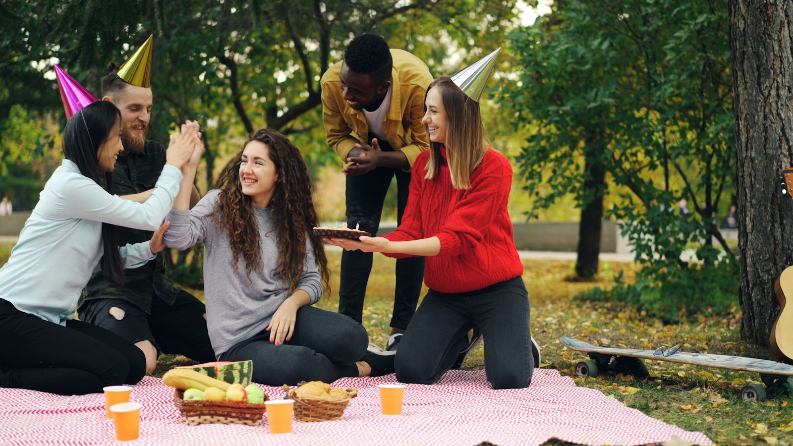 Members celebrating together outdoors with fruit and drinks